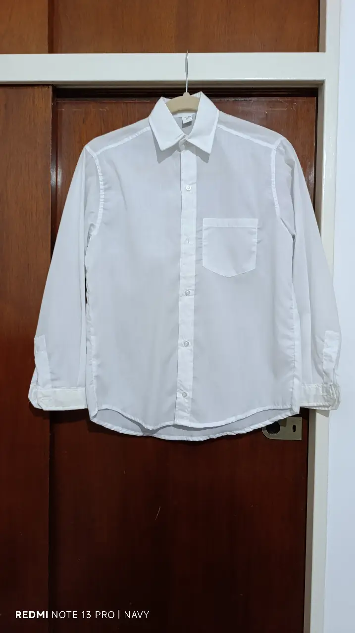 Camisa blanca de niño, manga larga, con bolsillo en el pecho. Talle 12, ideal para un look casual o formal.