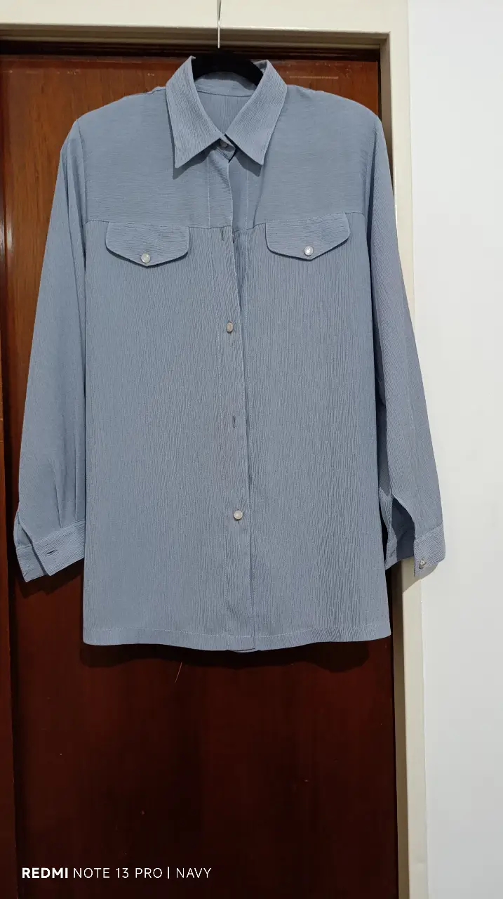 Conjunto de camisa y pantalón de vestir en color azul. La camisa, con mangas largas y bolsillos delanteros, presenta un diseño elegante y versátil. El pantalón, de corte recto, complementa el conjunto, ideal para un look sofisticado y moderno.