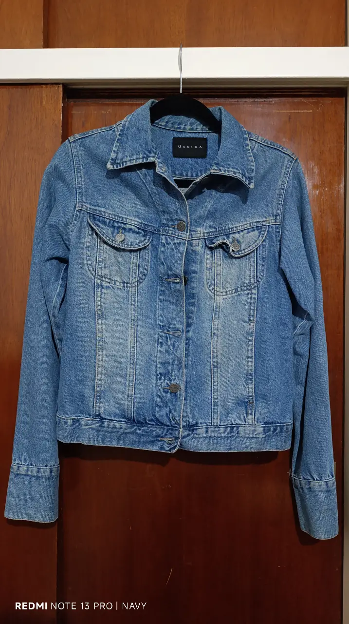 Campera de jean azul de la marca Ossira, con dos bolsillos delanteros y botones. Talle M/Medium.