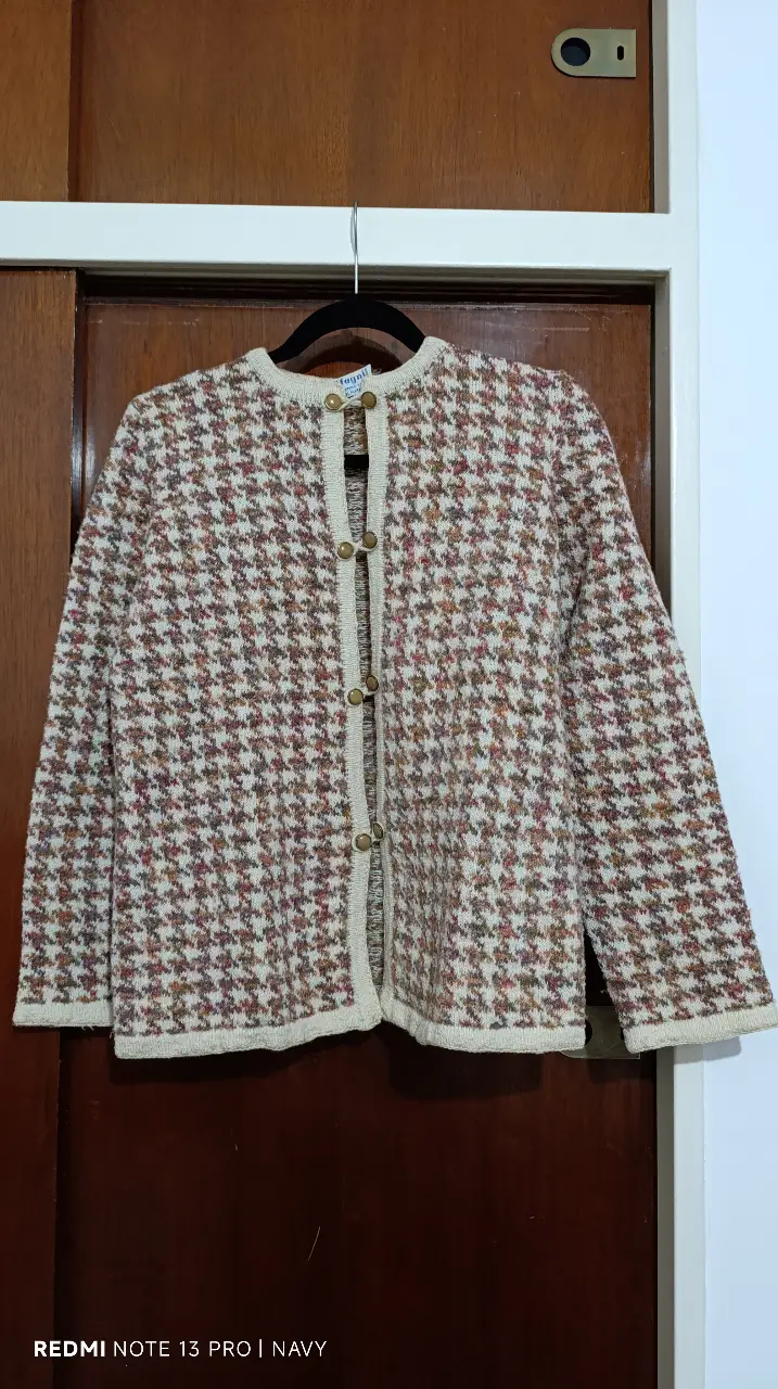 Conjunto de cardigan y pollera de lana con estampado de pata de gallo. El cardigan tiene botones dorados y la pollera es de corte recto. Ideal para un look vintage y elegante.