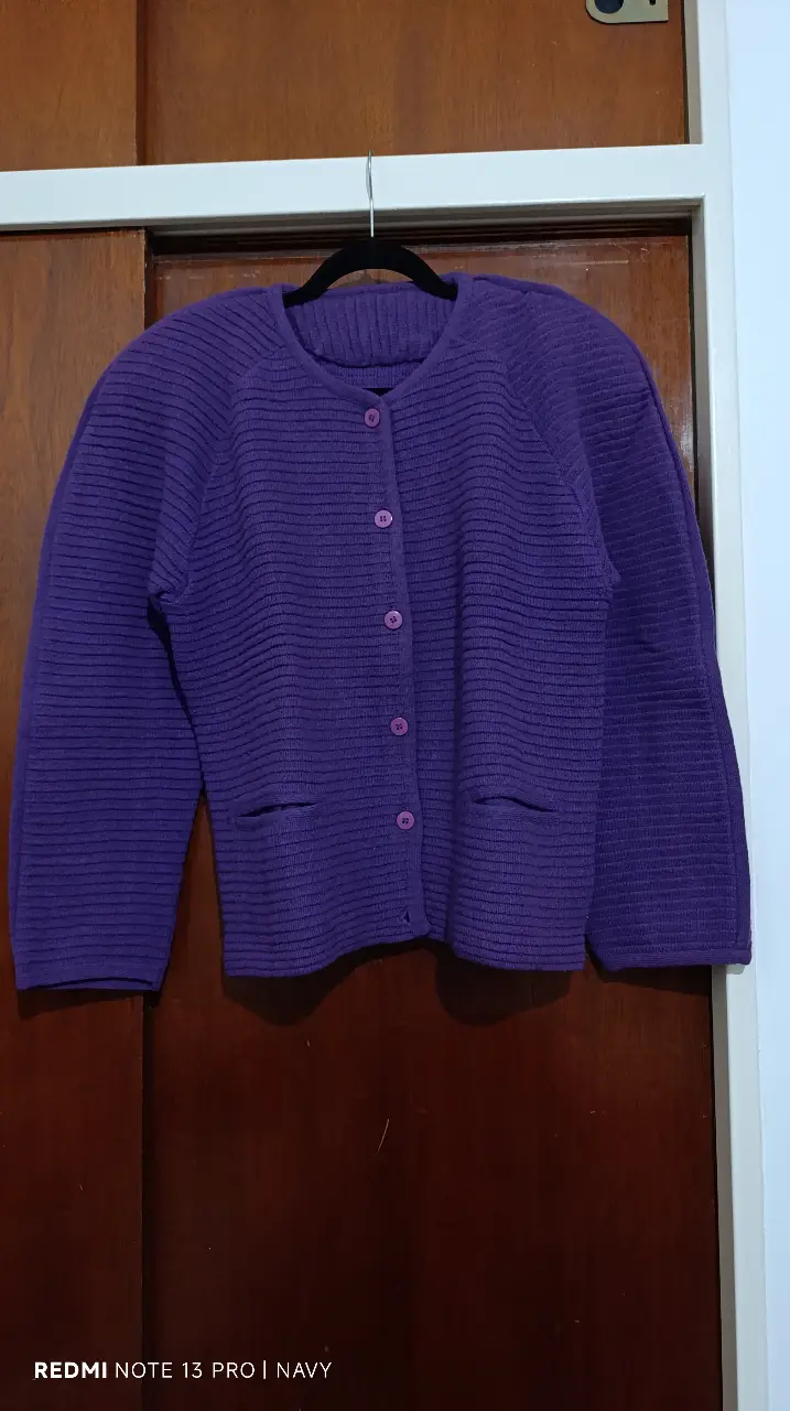 Cardigan de punto grueso en color violeta, con botones y bolsillos delanteros. Ideal para un look casual y abrigado.