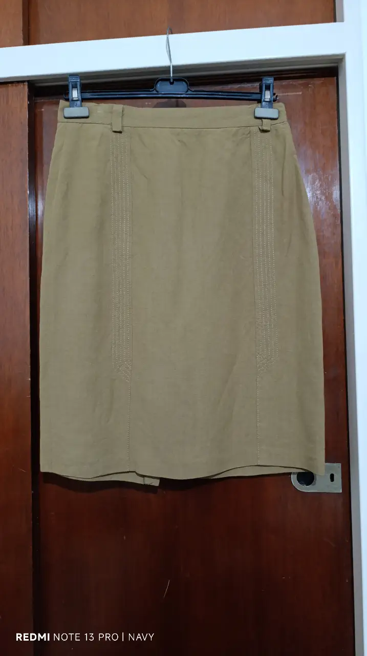 Pollera sastrera color marrón, con detalle de costuras verticales en la parte delantera. Confeccionada en una mezcla de viscosa y lino, con talle 44. Ideal para un look elegante y sofisticado.