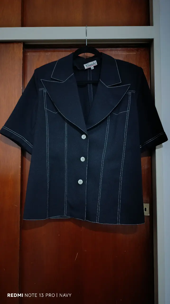 Blazer negro de manga corta con detalles en blanco. Ideal para un look elegante y moderno. Confeccionado con tela de calidad, este blazer es perfecto para cualquier ocasión.