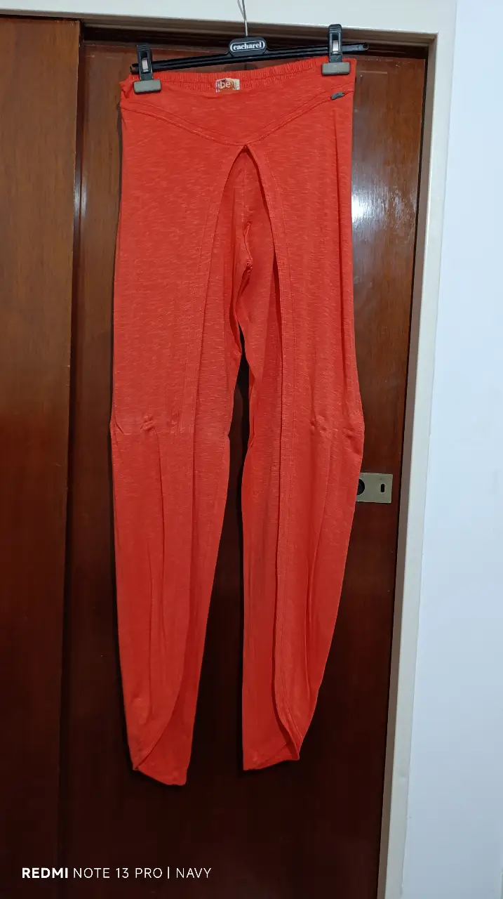 Pantalón suelto naranja con abertura frontal. Ideal para un look casual y cómodo.
