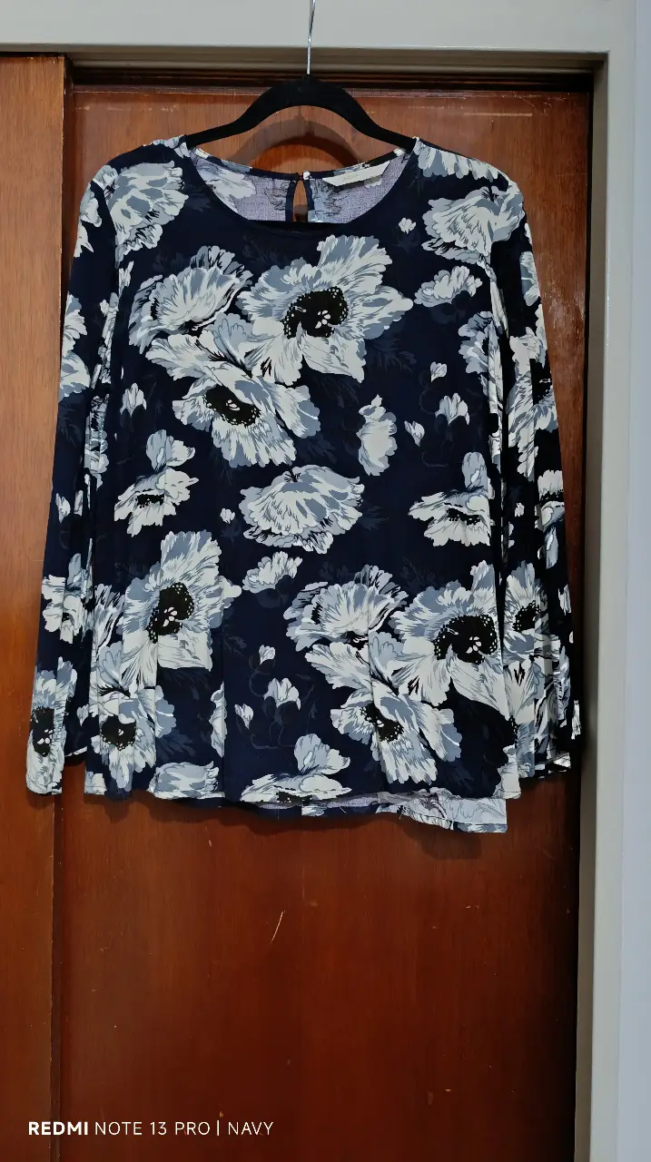 Blusa de mujer con estampado floral en tonos azul marino y blanco. Manga larga y cuello redondo. Ideal para un look casual y elegante.