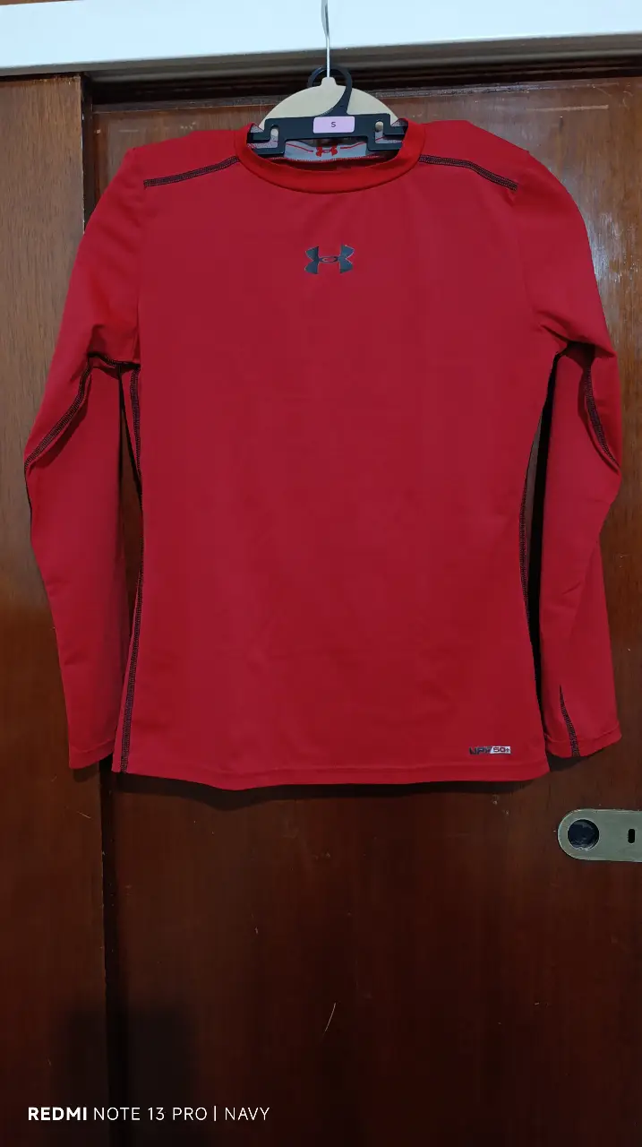 Remera deportiva manga larga roja, para niño/adolescente ideal para entrenamientos y actividades al aire libre. Confeccionada con tejido técnico que ofrece protección solar UPF 50+. Diseño ajustado y logo de la marca en el pecho.