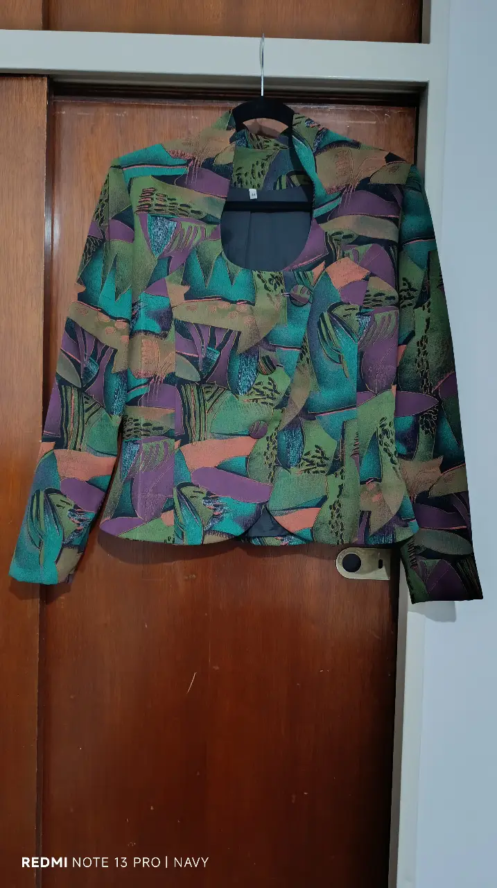 Blazer de mujer con estampado abstracto en tonos verdes, morados y naranjas. Corte clásico con solapas y un botón. Ideal para un look retro y con estilo.