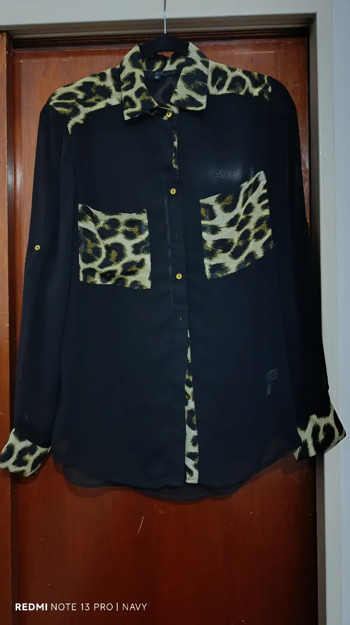 Camisa de mujer negra con estampado de leopardo en cuello, bolsillos y puños. Ideal para un look casual o de fiesta.