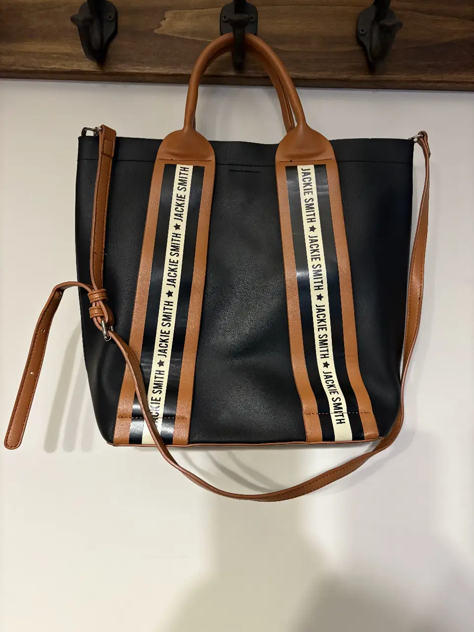 Bolso tote negro con detalles marrones y cintas con la inscripción 'JACKIE SMITH'. Ideal para llevar todo lo necesario con estilo.