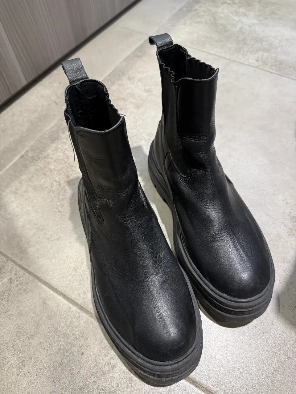 Botines negros de cuero con suela gruesa. Ideales para un look moderno y urbano. Perfectos para combinar con jeans, faldas o vestidos.