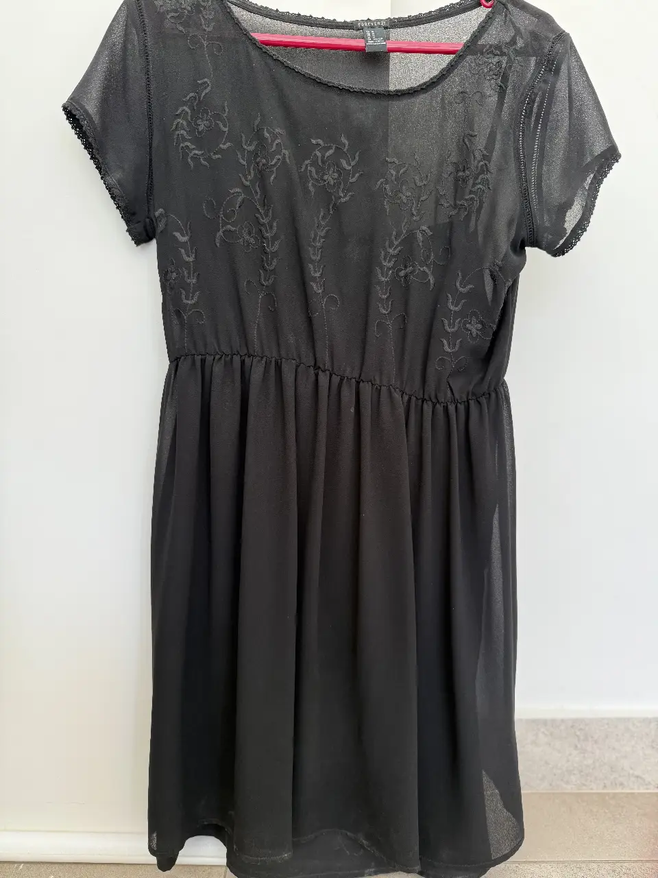 Vestido mini negro de Forever 21, con detalles bordados en la parte superior y cintura elastizada. detalle de vainilla en sisa y enagua incluida sostenida en hombros internos. Ideal para una salida casual o una fiesta.