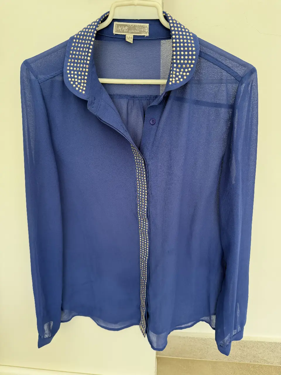 Blusa azul con cuello y detalles de strass. Ideal para un look elegante y sofisticado.
