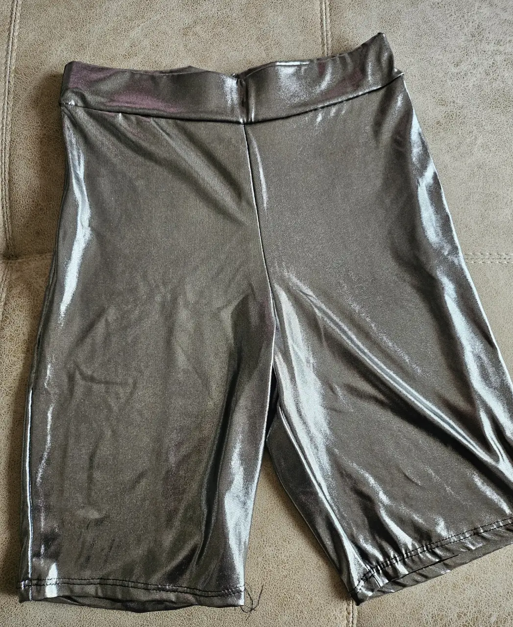 Shorts deportivos de mujer, color gris metalizado, ideales para actividades de baile o eventos rave. Diseño ajustado y moderno.