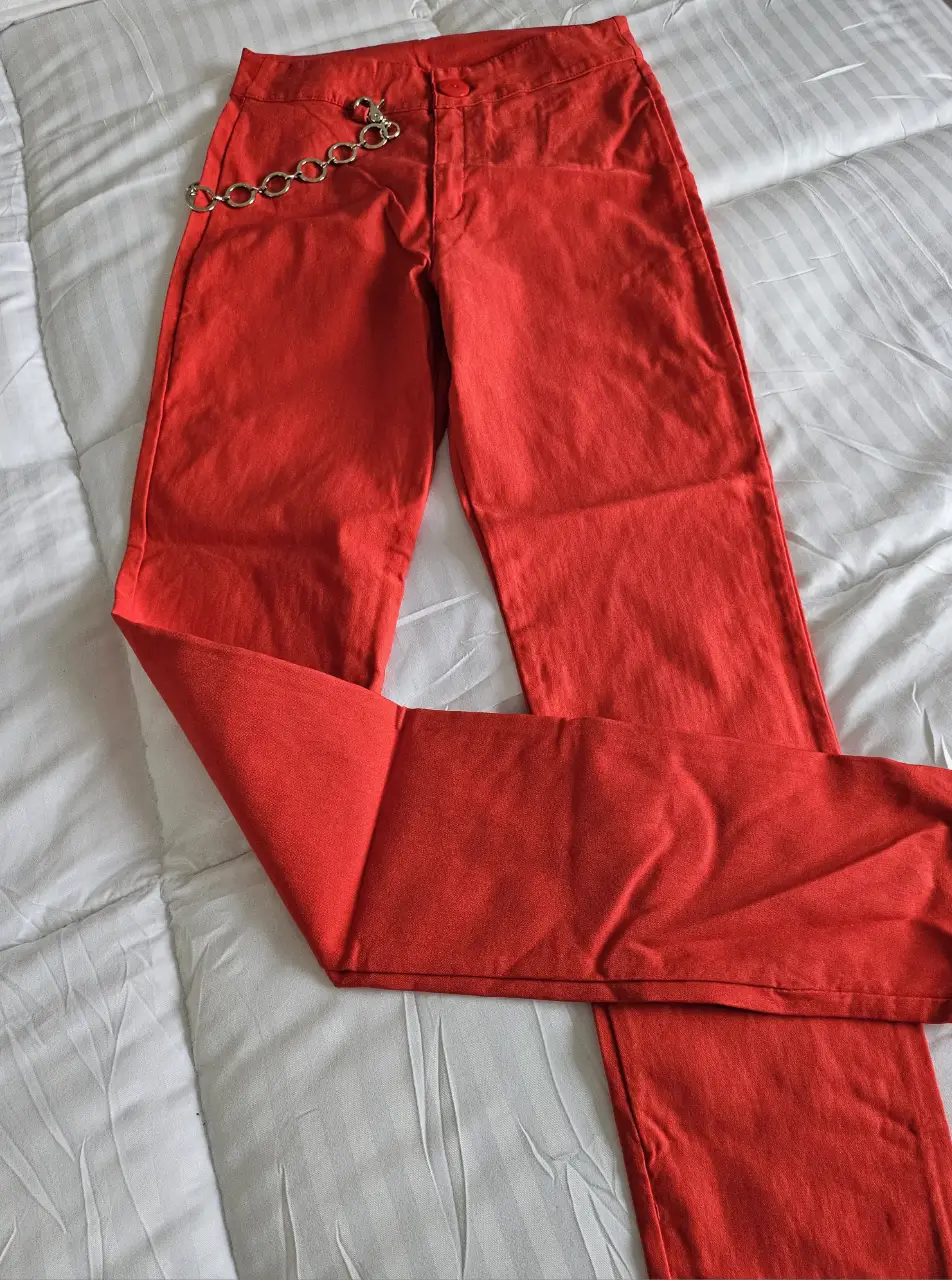 Pantalón rojo de corte recto con detalle de cadena. Ideal para un look moderno y audaz.