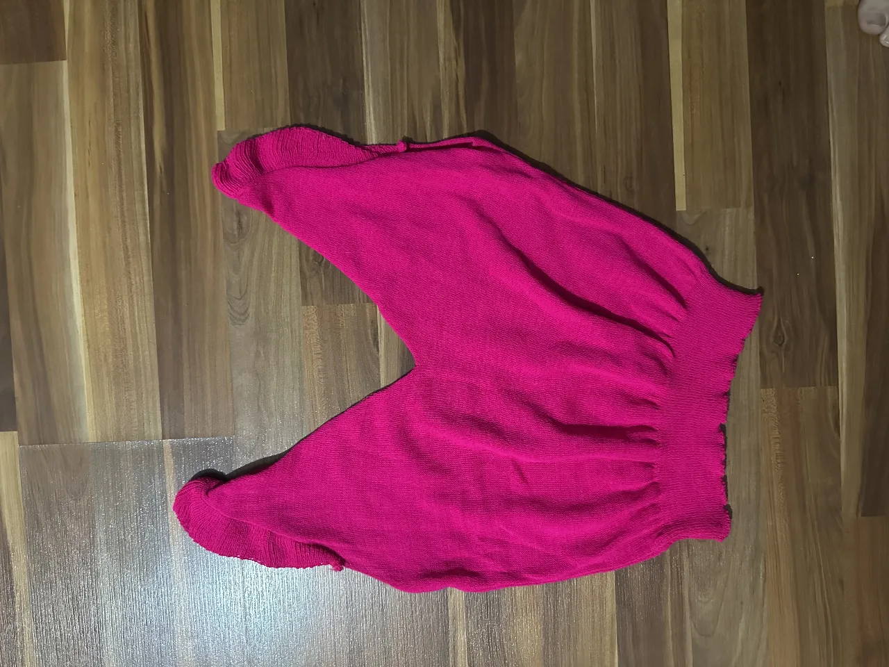 Musculosa tejida de color rosa, ideal para un look casual y cómodo. Perfecto para el verano. Detalle de volado en los hombros. Divina 