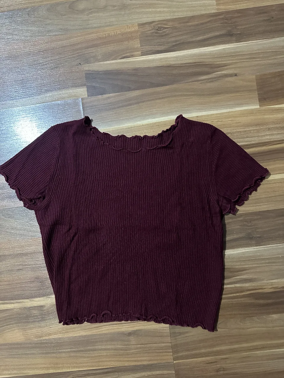 Remera de mujer de color borgoña, con cuello y mangas con volados. Ideal para un look casual y femenino.
