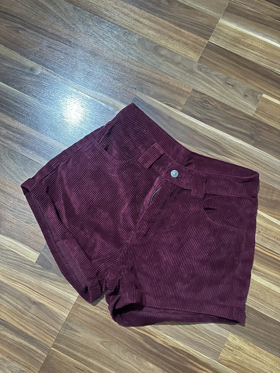 Short de mujer de corderoy color borgoña, tiro alto, con bolsillos delanteros y cierre con botón y cremallera. Talle 40.