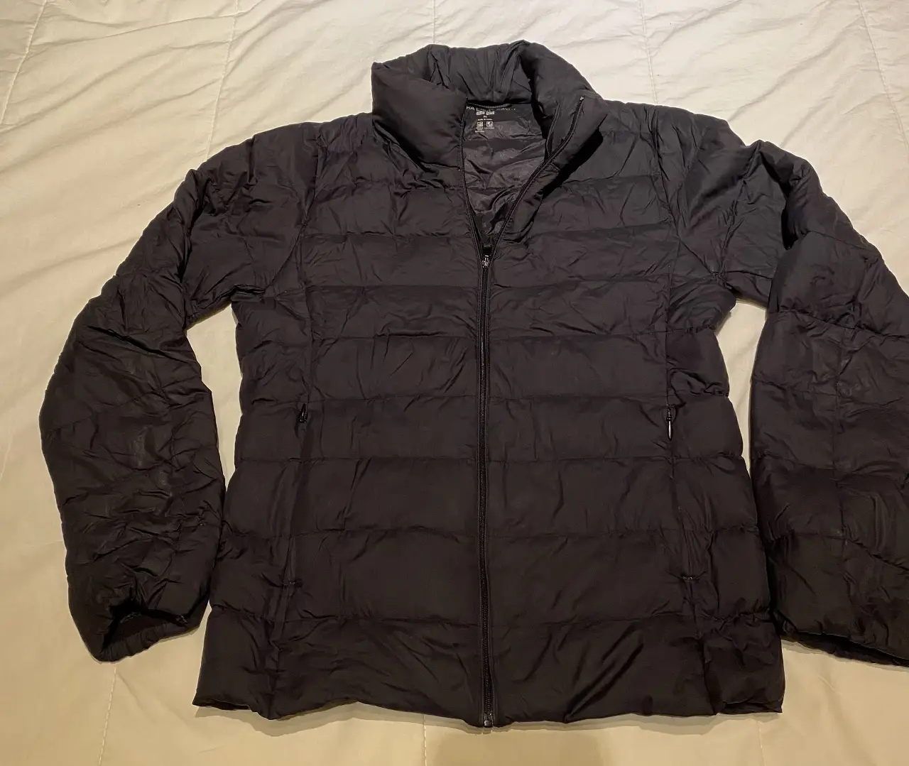 Campera de pluma negra Uniqlo Ultra Light Down, talle XS. Ideal para el invierno, liviana y abrigada. Cuenta con cierre y bolsillos.
