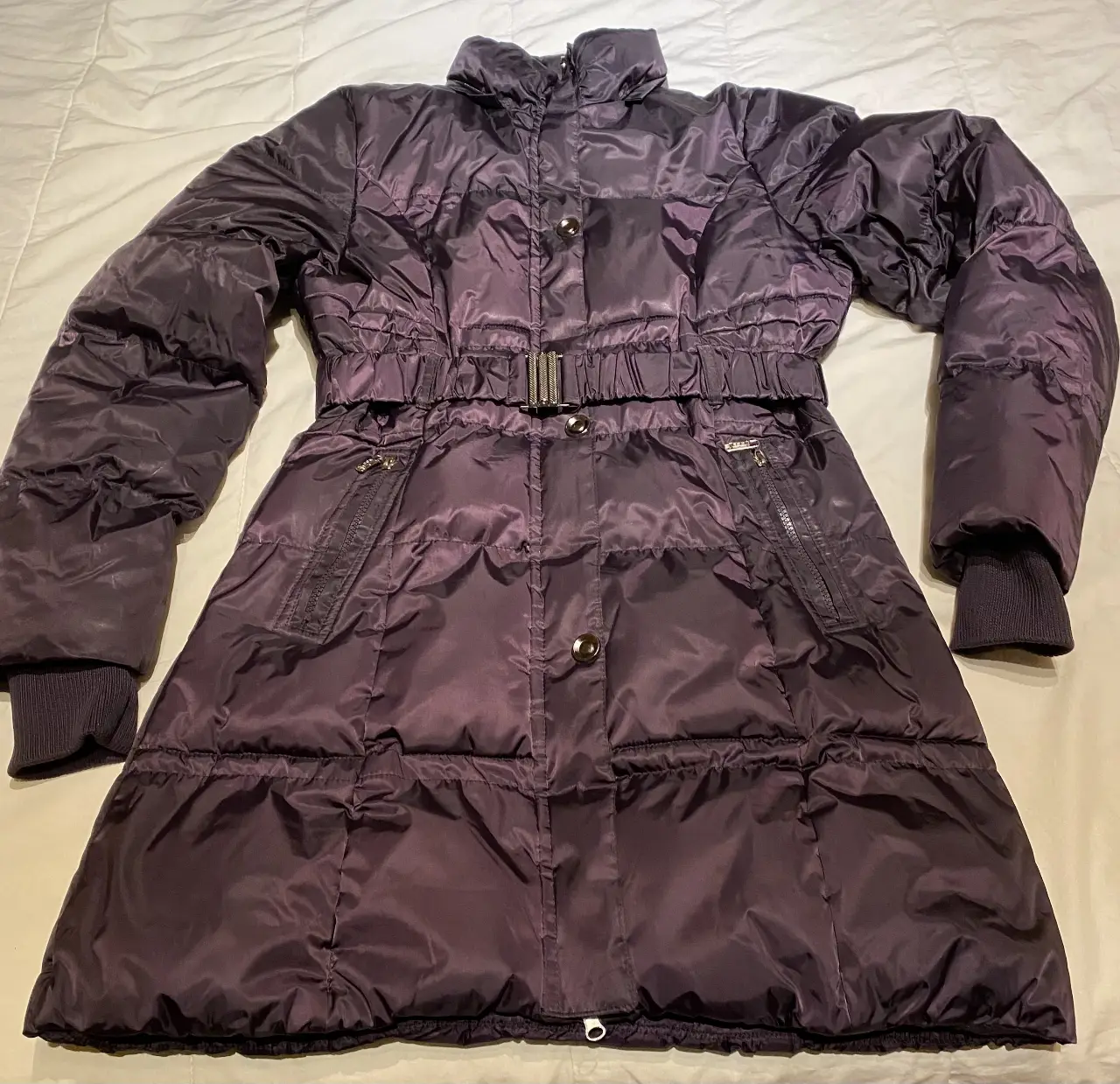 Campera de pluma acolchada para mujer, color violeta oscuro. Con cinturón y detalles de cierre. Ideal para el invierno.