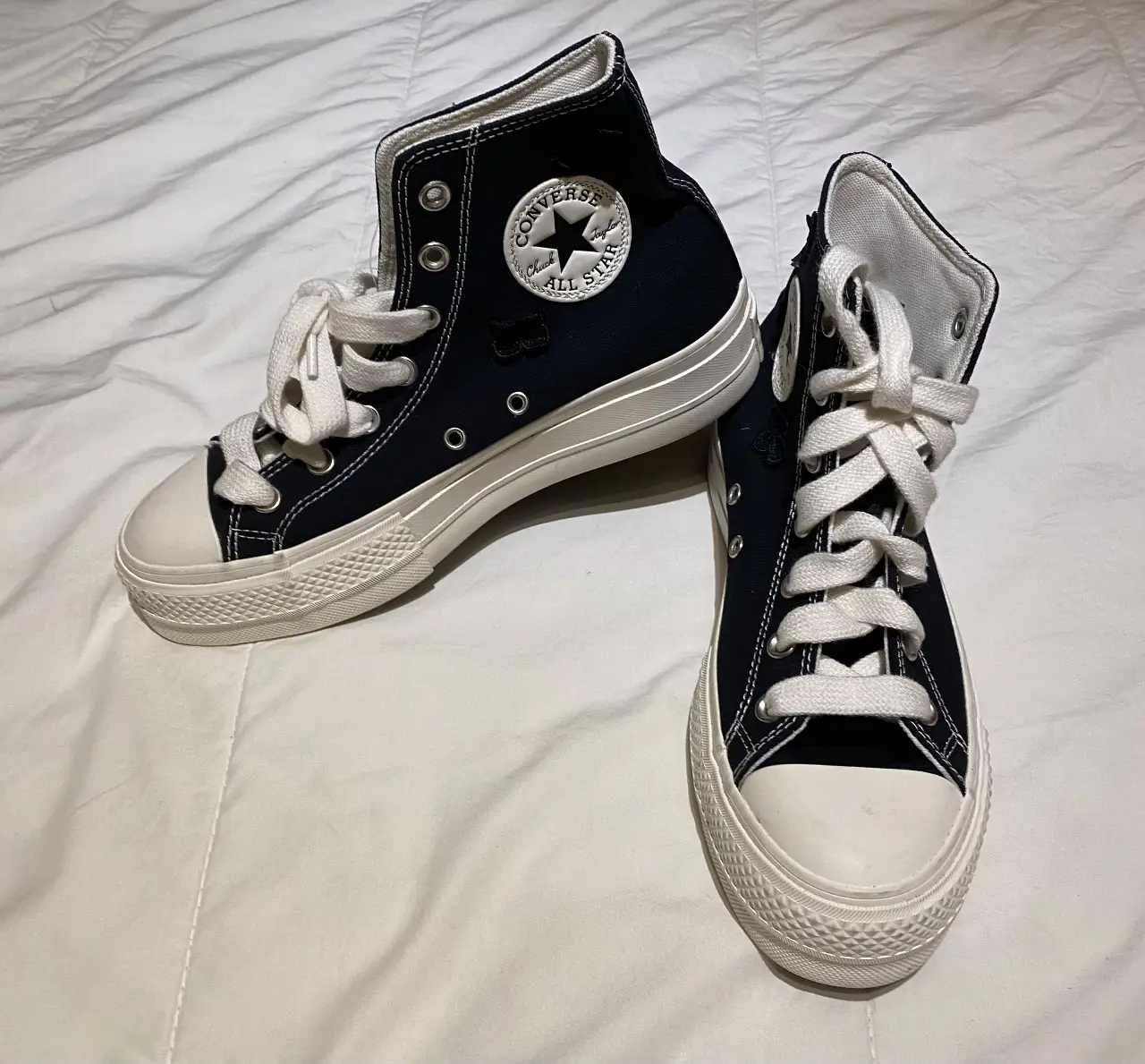 Zapatillas Converse All Star negras con detalles de mariposas en relieve. Diseño de caña alta con cordones blancos y suela blanca. Un clásico renovado para un look urbano y con estilo.
