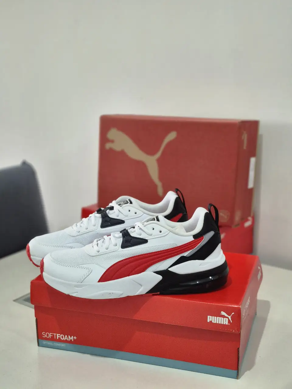 Zapatillas Puma para hombre, blancas con detalles en rojo y negro. Ideales para uso diario y actividades deportivas.