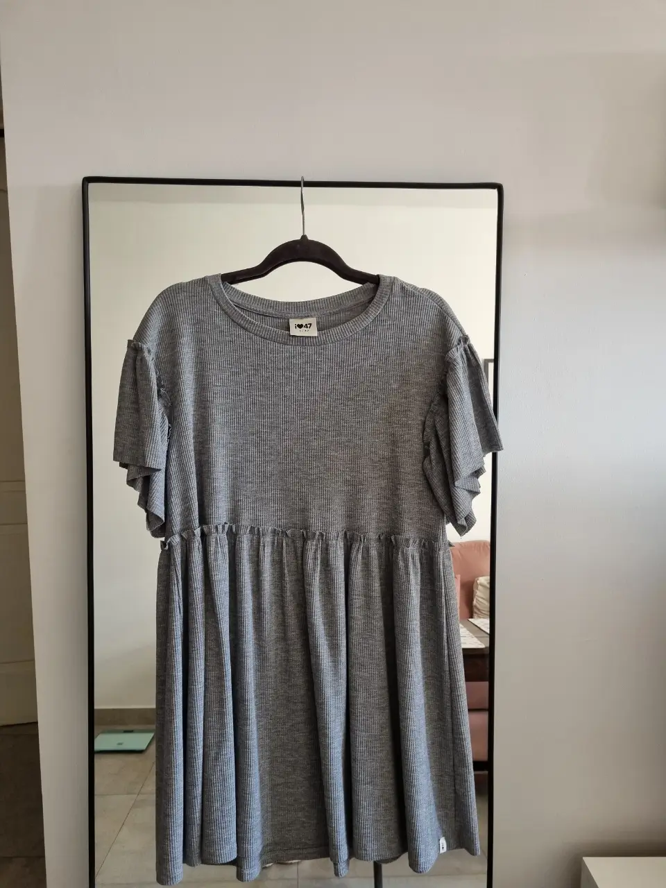 Vestido midi gris de tejido waffle con mangas cortas con volados y detalle fruncido en la cintura. Ideal para un look casual y cómodo.