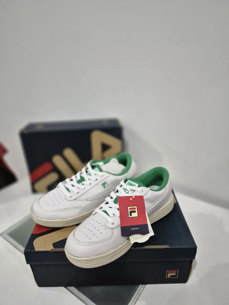 Zapatillas Fila blancas con detalles en verde, ideales para un look casual y deportivo. Diseño clásico y cómodo, perfectas para el día a día.