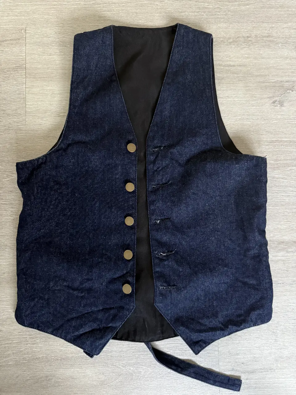 Chaleco de jean azul oscuro, con botones dorados y ajuste en la espalda. Ideal para un look casual y canchero.