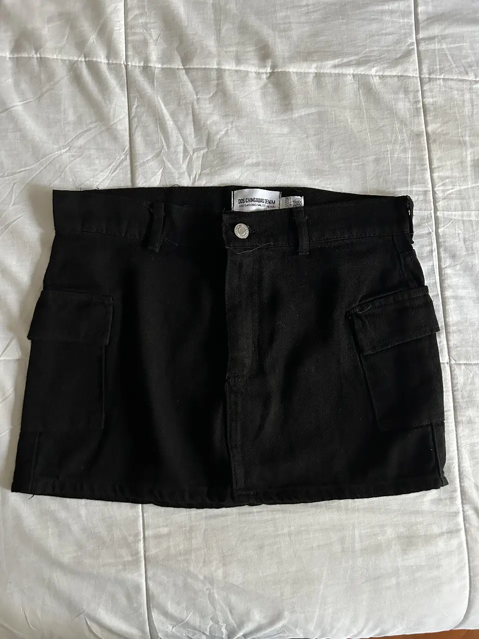 Minifalda cargo negra de jean, con bolsillos laterales. Talle 38.