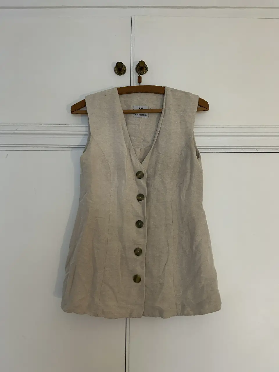 Chaleco sastrero de lino color crudo, con botones y cuello en V. Ideal para un look casual y elegante. Marxa Yagmour.