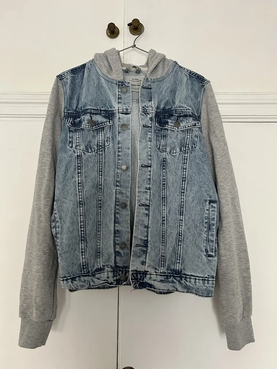 Campera de jean con mangas y capucha de tela gris. Ideal para un look casual y canchero. Talle S.