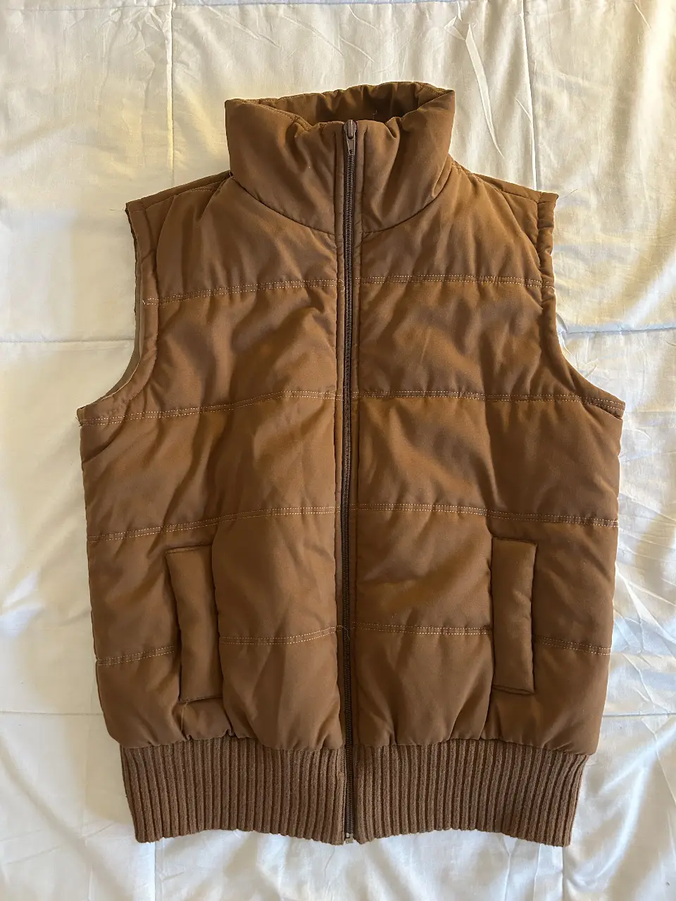 Chaleco marrón acolchado, ideal para el invierno. Con cierre y bolsillos.