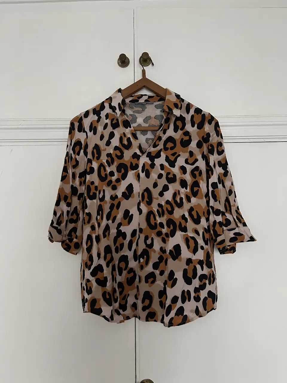 Blusa con estampado de leopardo, manga 3/4 y cuello en V. Ideal para un look casual y con estilo.