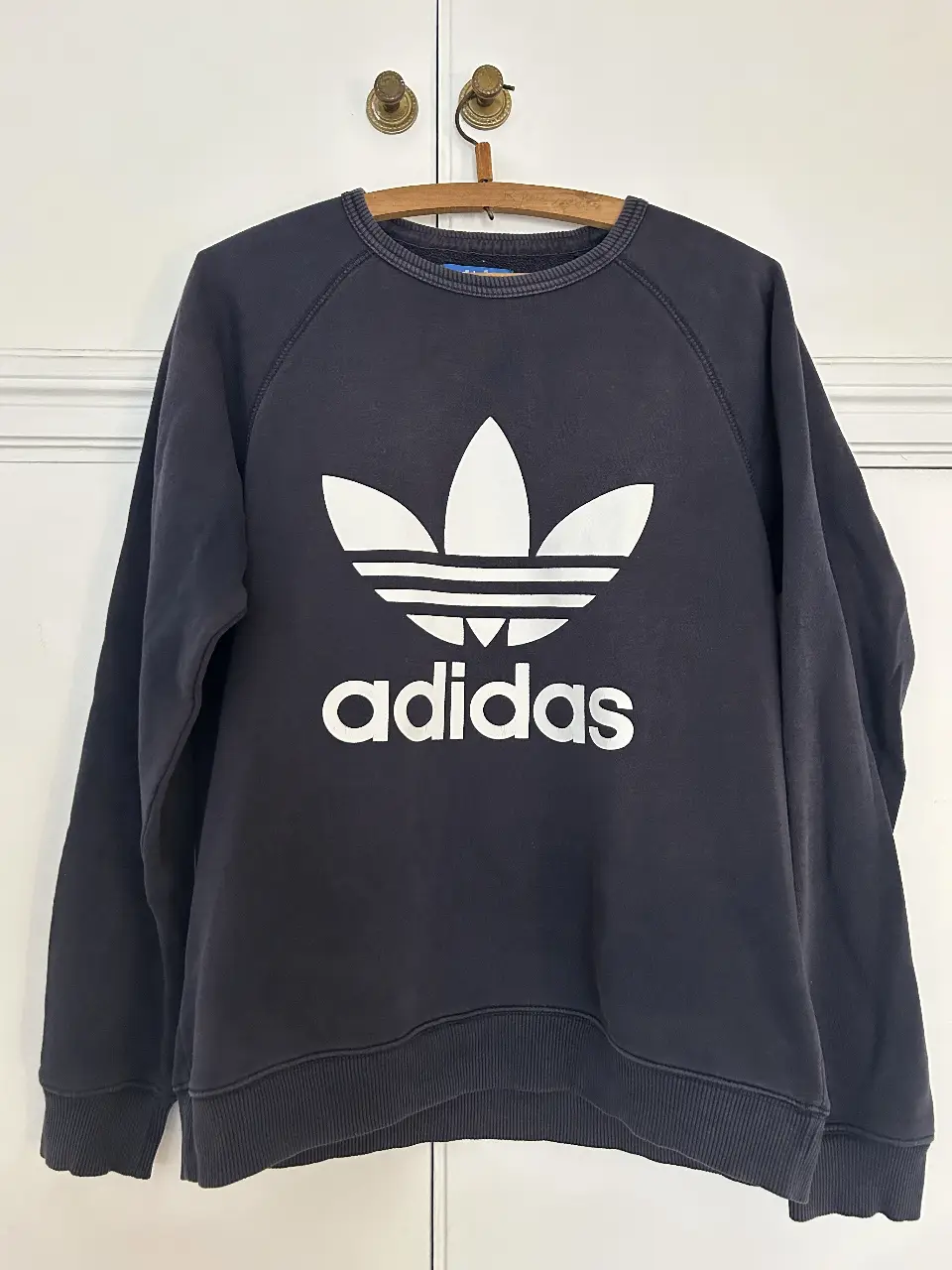 Buzo de cuello redondo Adidas violeta oscuro con el logo blanco. Talle S. Ideal para un look casual y deportivo. Medidas: 64cm largo total, 53cm de axila a axila, 65cm largo de manga desde hombro