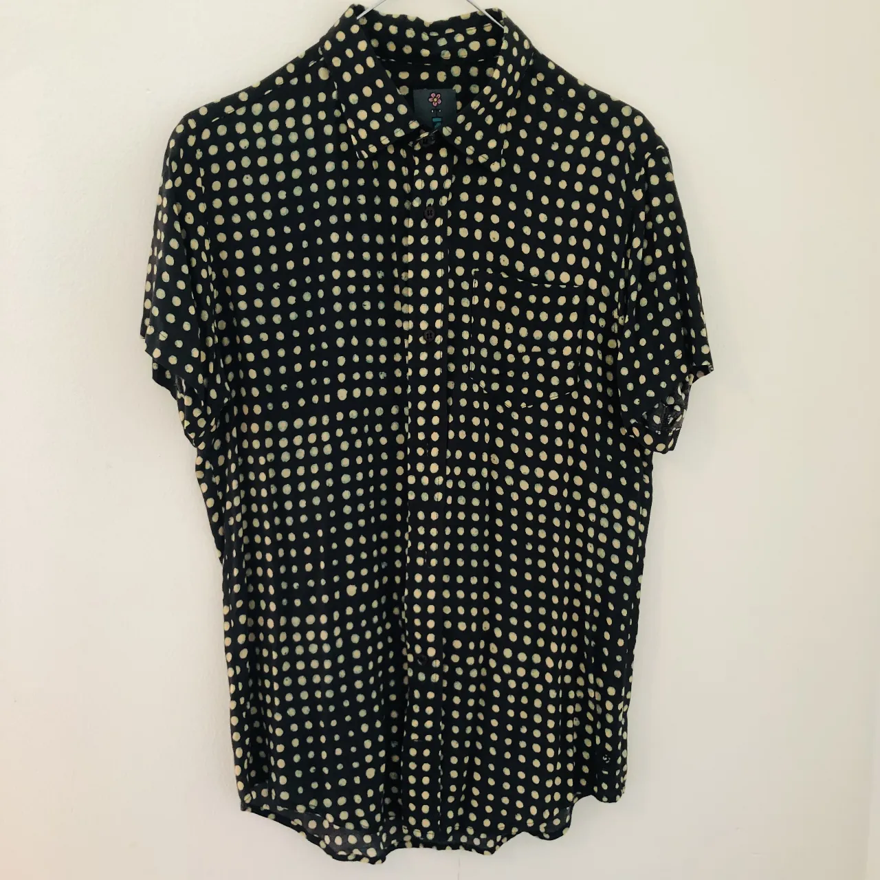 Camisa de hombre con estampado de lunares en negro y blanco. Corte clásico, manga corta y cuello camisero. Ideal para un look casual con un toque retro.