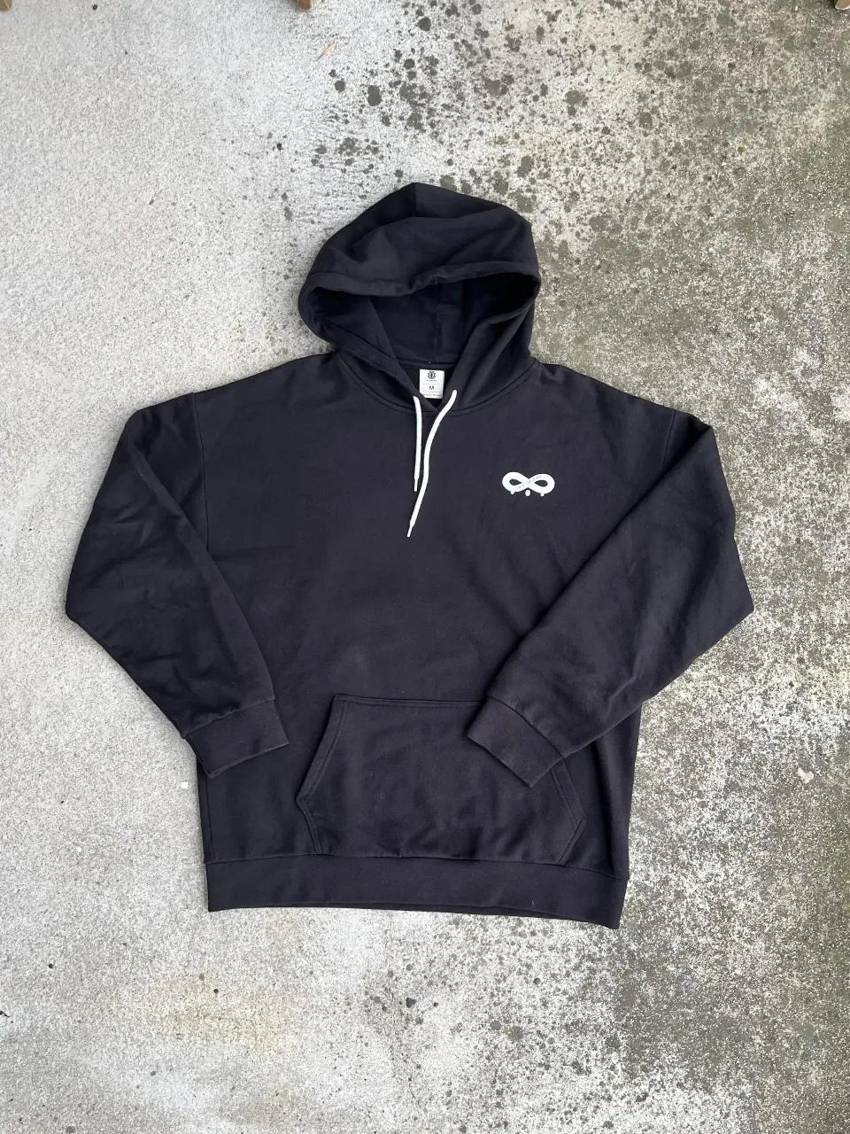 Buzo canguro negro con capucha y el logo de un infinito en blanco en el pecho. En la espalda, un número 8 grande en blanco. Ideal para un look casual y urbano.