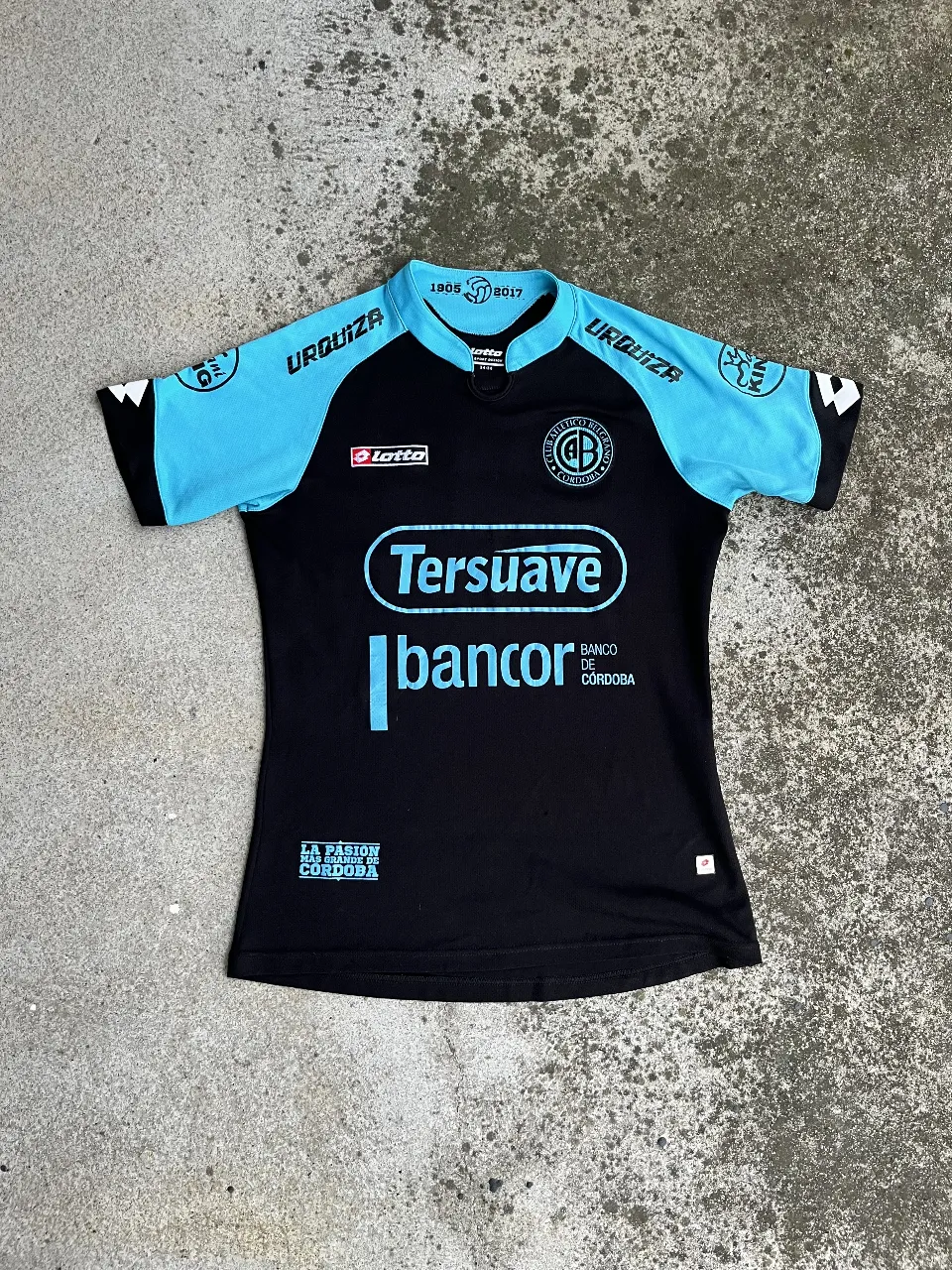 Camiseta de fútbol del Instituto Atlético Central Córdoba. Diseño en negro con detalles en celeste, ideal para fanáticos y coleccionistas. Con logos de Lotto y auspiciantes.