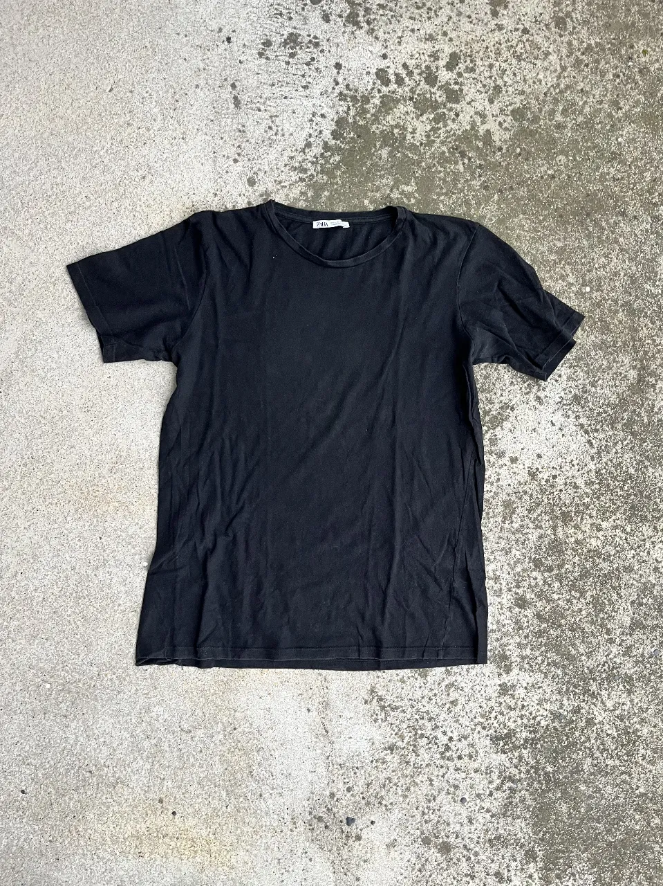 Remera negra de manga corta, de la marca Zara. Ideal para un look casual y versátil.