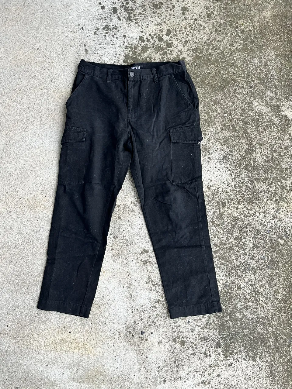 Pantalón cargo negro de hombre, con múltiples bolsillos y corte recto. Ideal para un look casual y funcional.
