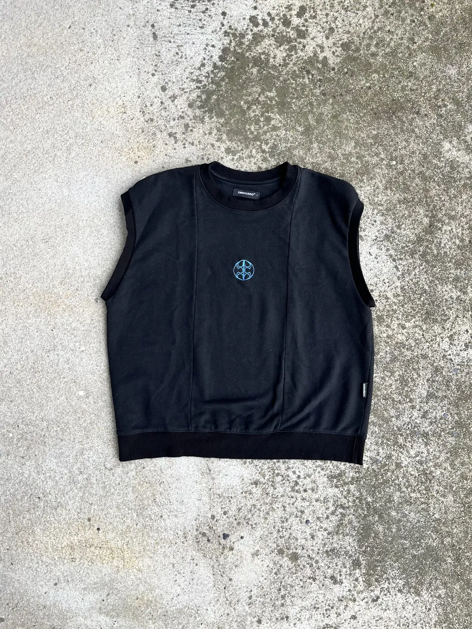 Musculosa de jersey rústico negra sin mangas con un diseño distintivo en el pecho. Ideal para un look casual y moderno.