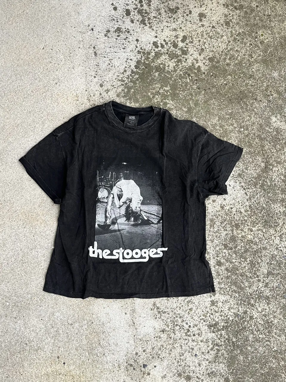 Remera negra de algodón con estampado de la banda The Stooges. Estilo vintage, ideal para un look rocker y casual.