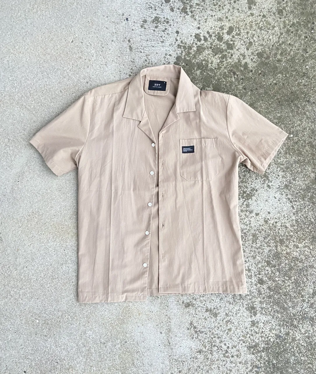 Camisa de hombre manga corta en color crudo, con bolsillo en el pecho y cuello tipo solapa. Ideal para un look casual y fresco.
