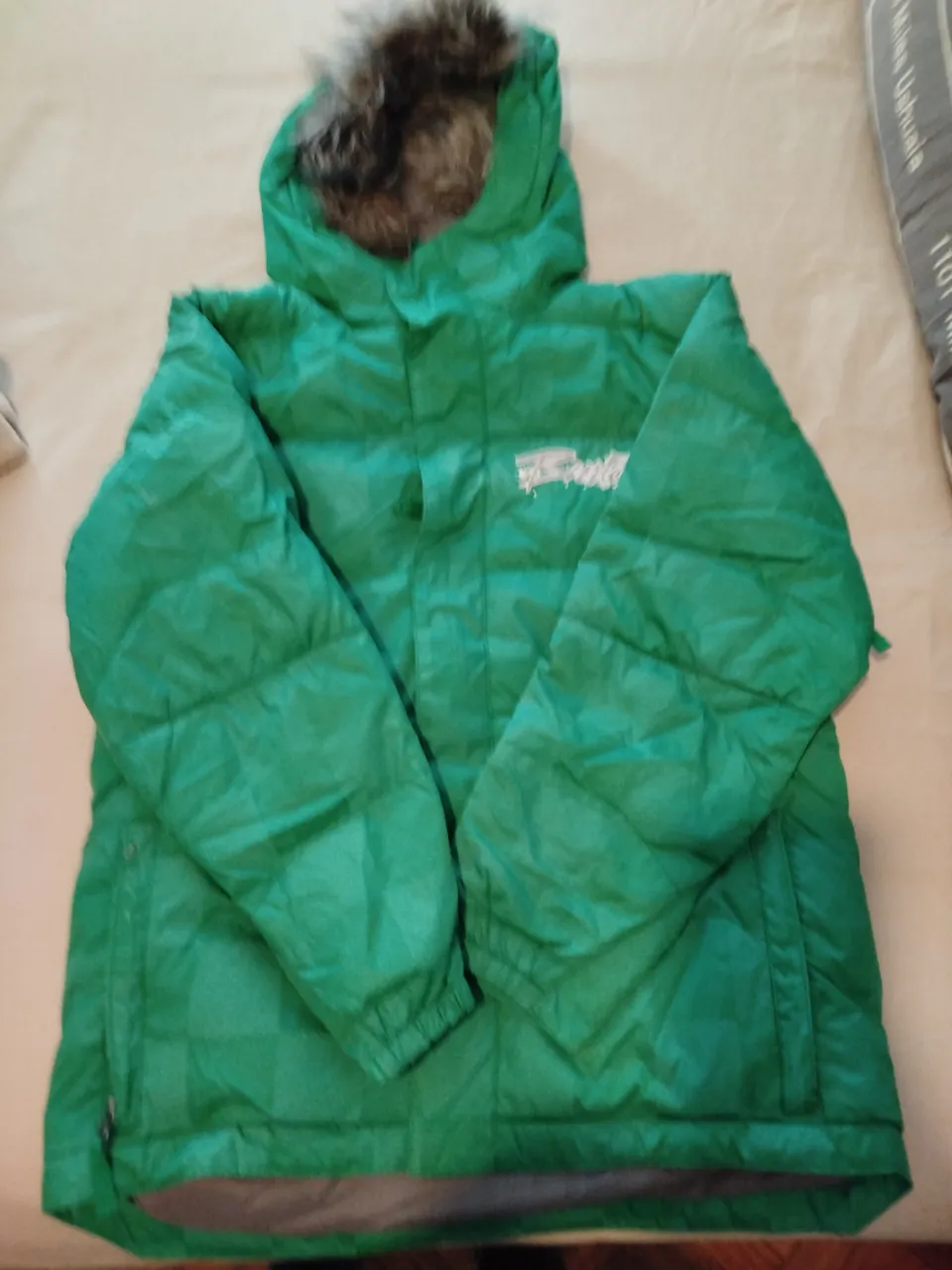 Campera de abrigo verde con capucha y piel sintética. Ideal para el invierno, con cierre y detalles de la marca Burton. Talle L.