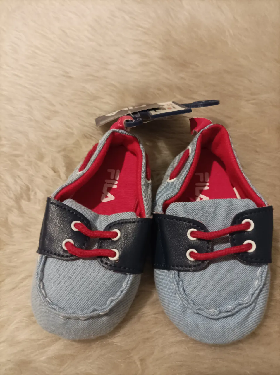 Zapatos náuticos Fila para bebé, color celeste con detalles en azul marino y rojo. Talle 9-12 meses.