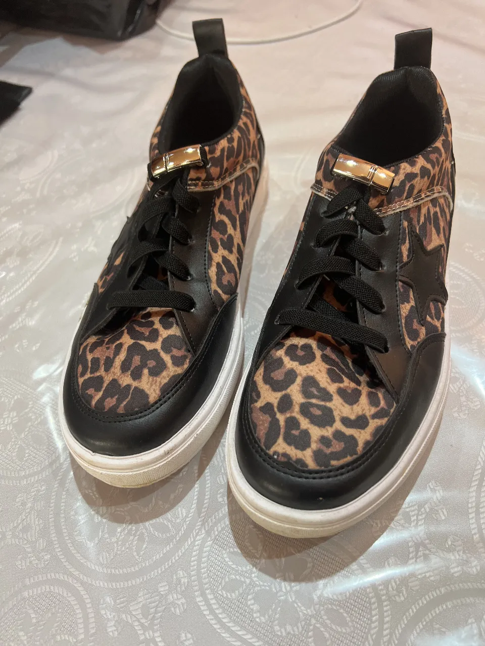 Zapatillas de mujer con estampado de leopardo y detalles en negro. Diseño moderno y canchero, ideales para un look casual y con estilo.