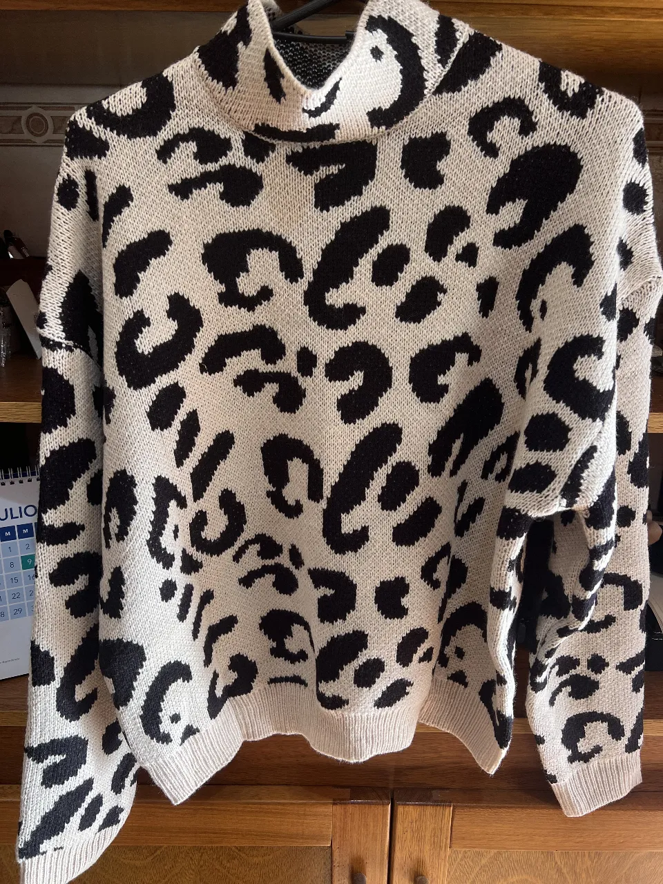 Sweater de mujer con estampado de leopardo en blanco y negro, cuello alto y diseño moderno. Ideal para un look casual y abrigado.