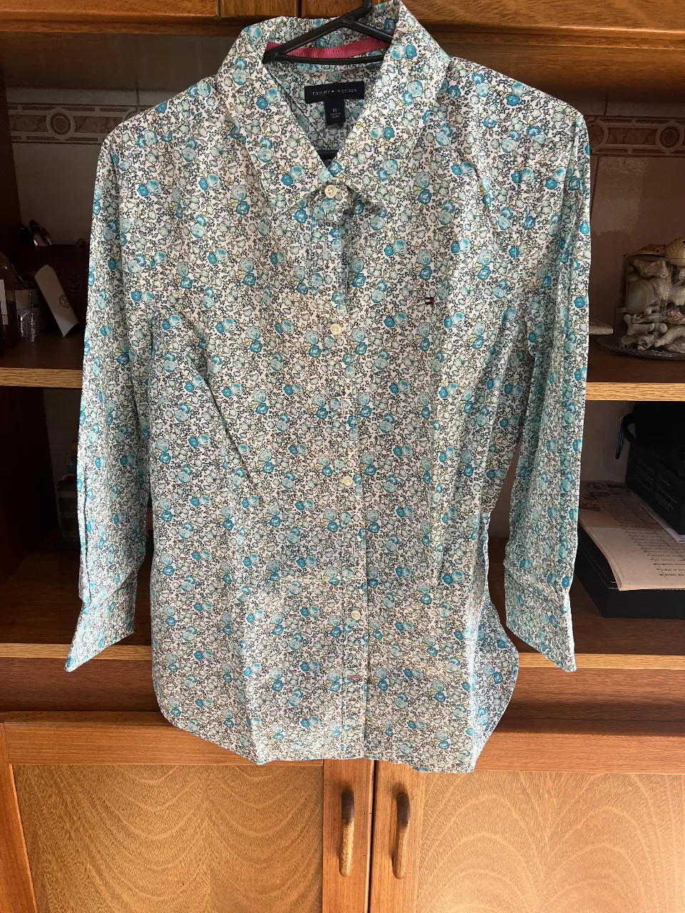 Camisa de mujer con estampado floral en tonos celeste y blanco. Manga larga, cuello camisero y cierre con botones. Ideal para un look casual y fresco.
