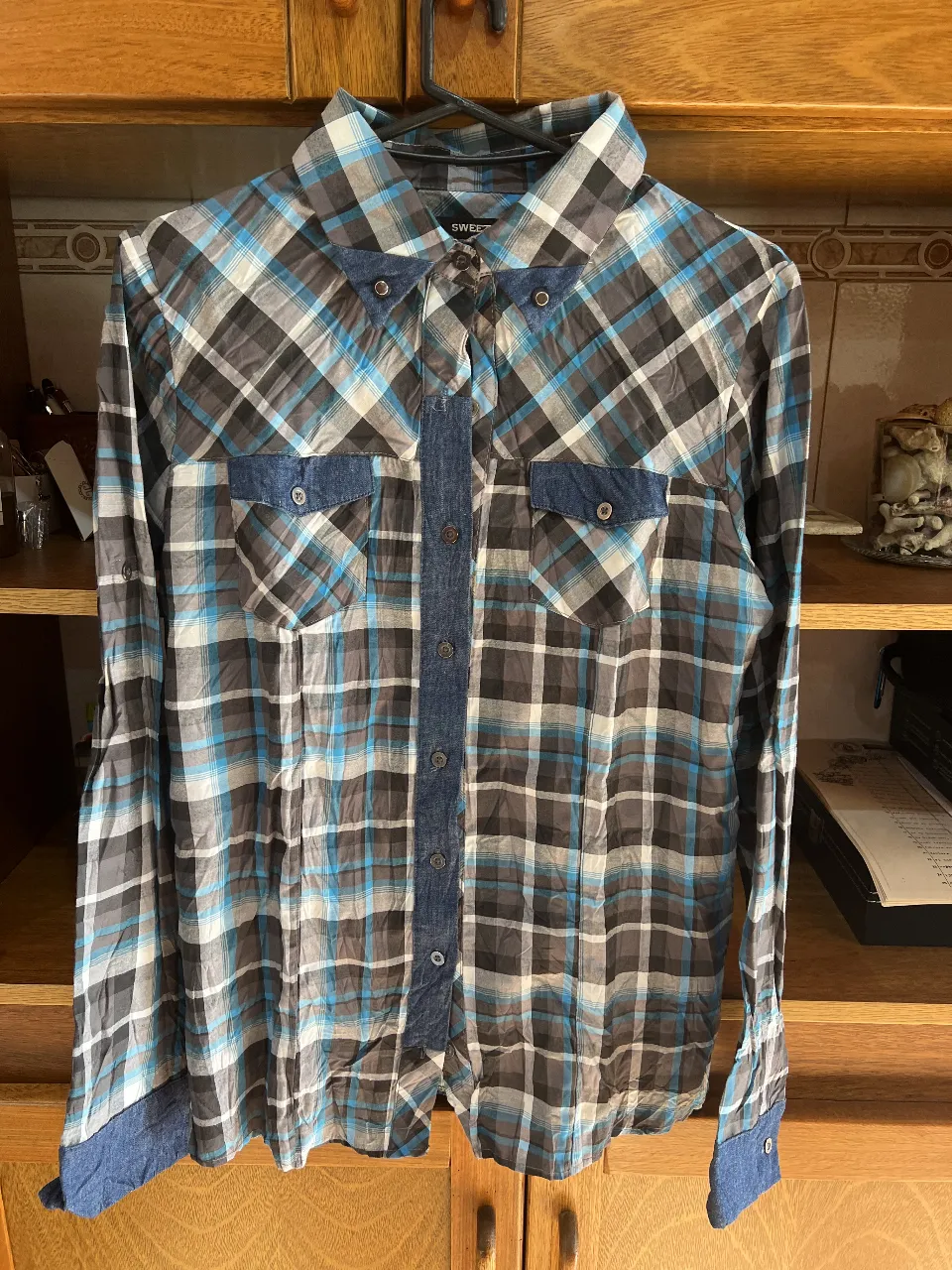 Camisa a cuadros para hombre, con detalles en azul marino en el centro y puños. Estilo casual y moderno.