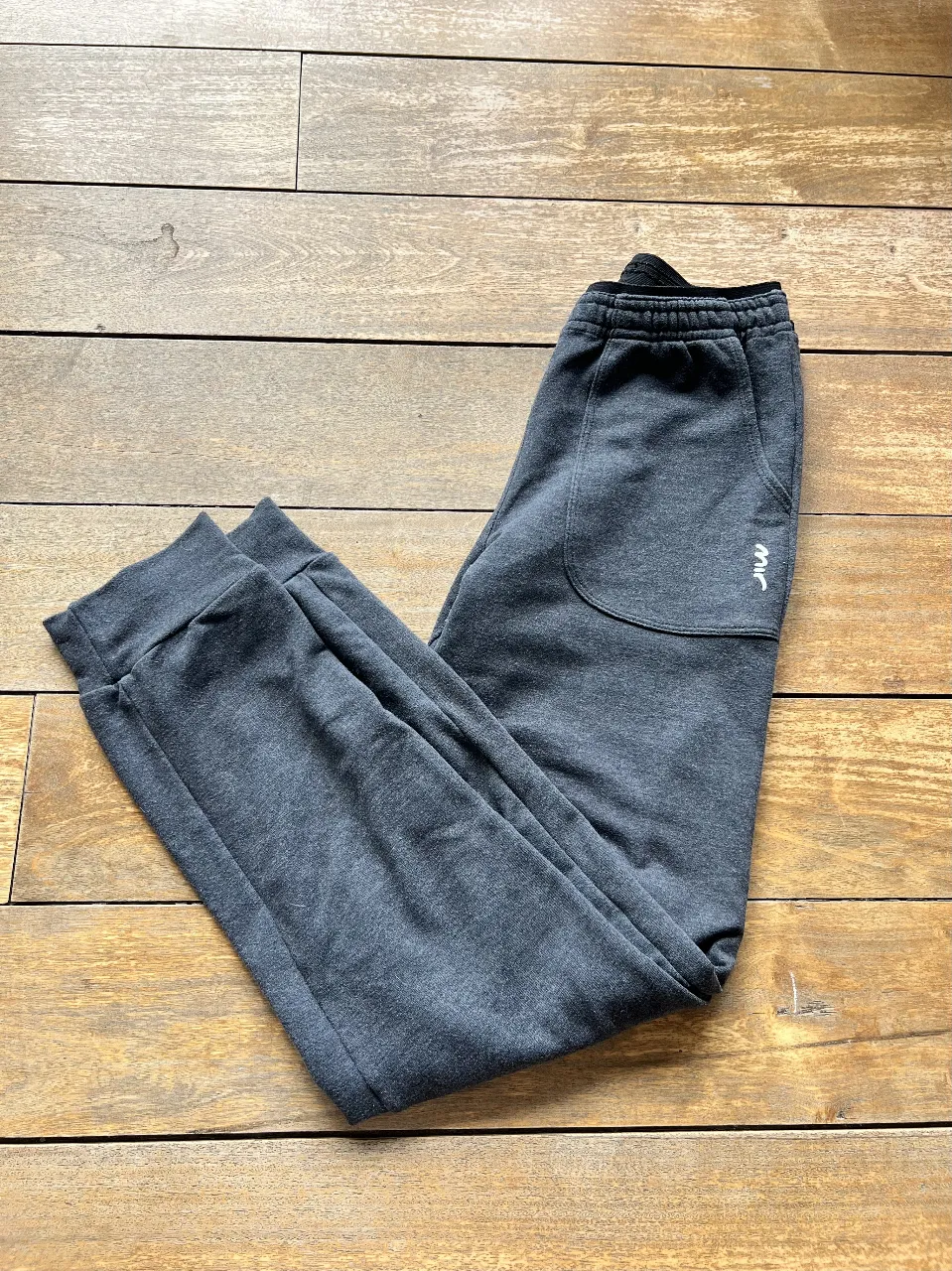 Pantalón de jogging gris de Mir Fitness para mujer. Tiro medio, con bolsillos laterales y puños en los tobillos. Ideal para un look casual y cómodo.
