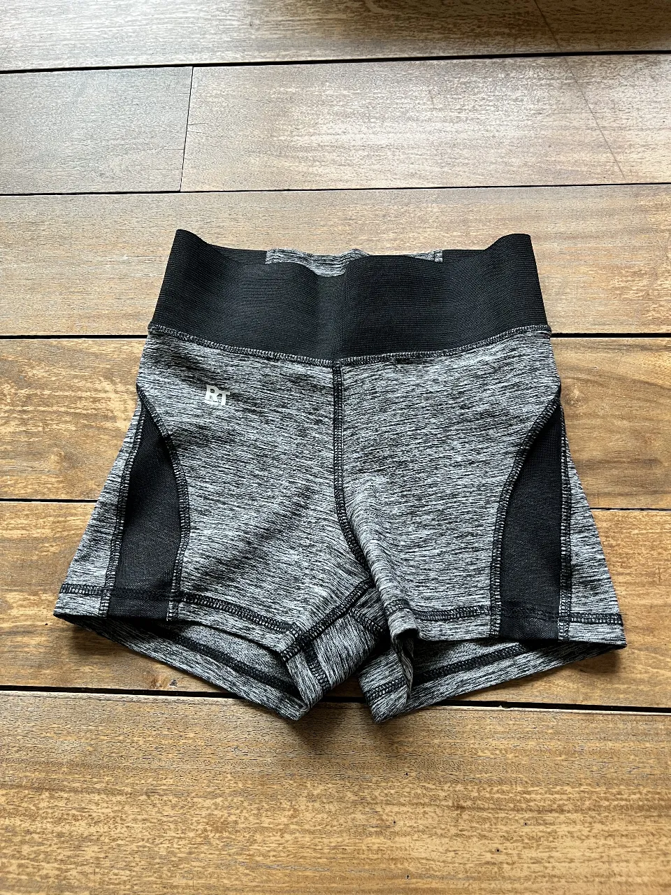 Short deportivo de mujer, ideal para entrenamientos. Confeccionado en tela elastizada gris con detalles en negro. Talle 1.